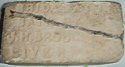 Cracked beige brick, lettering
